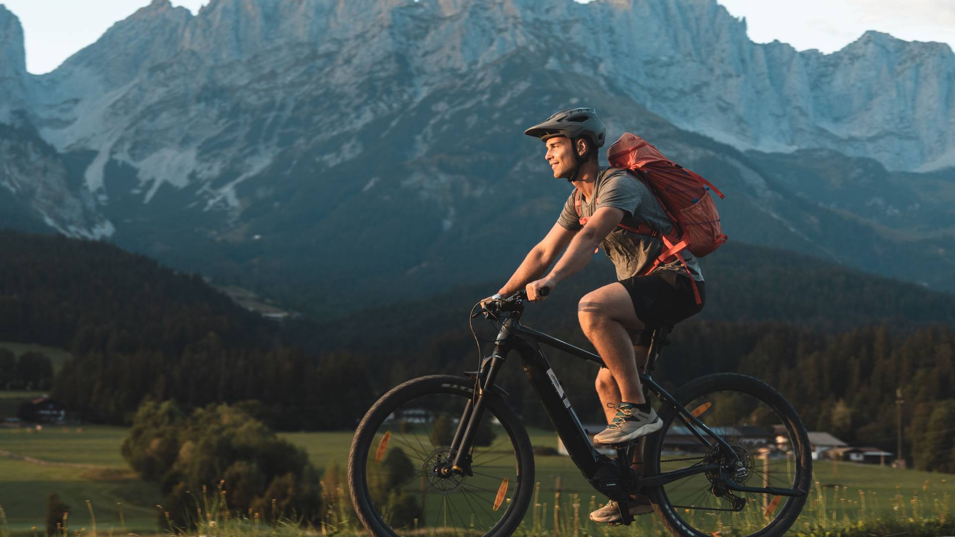 Mountainbiker fährt auf Straße am Wilden Kaiser